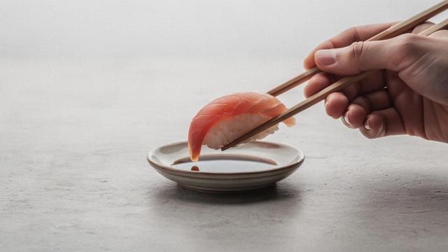 Soy sauce dish with chopsticks and a piece of nigiri